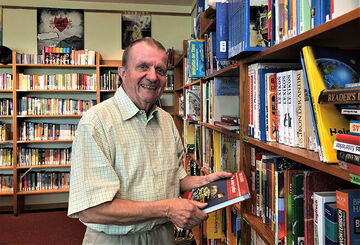 Gerd Lewin beim Blättern in einem Buch in der Schulbibliothek Gerd Lewin beim Blättern in einem Buch in der Schulbibliothek